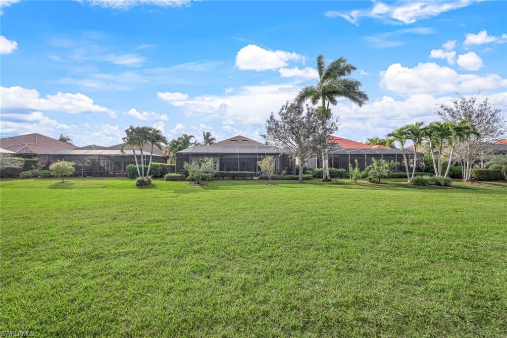 7688 Cottesmore Drive Naples, FL 34113 - Photo 40 of 45 a front view of a house with garden