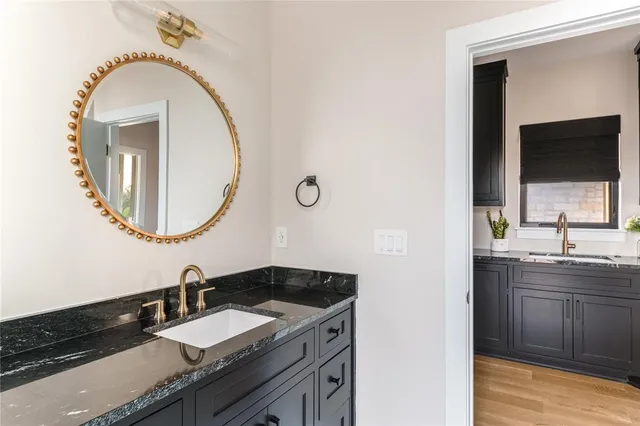 a bathroom with a granite countertop double vanity sink and a mirror