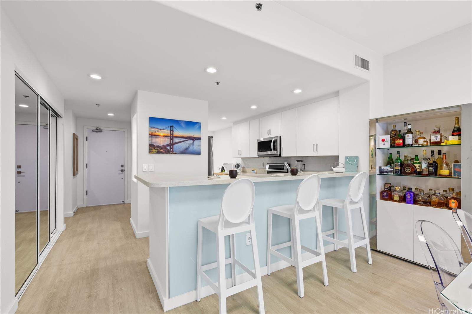 a kitchen with stainless steel appliances kitchen island granite countertop a refrigerator and cabinets