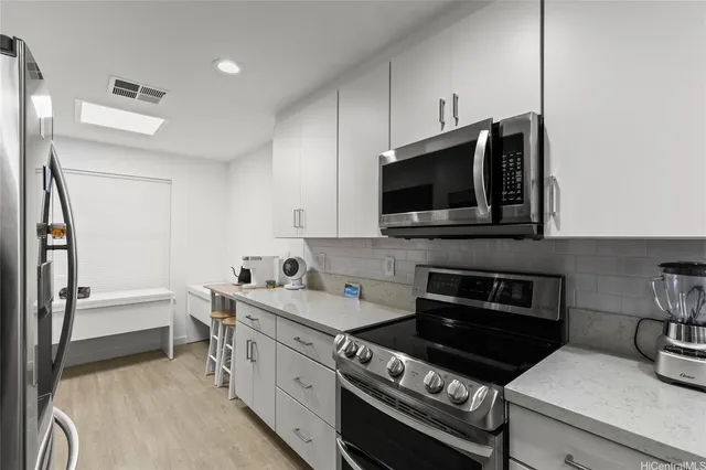 a kitchen with stainless steel appliances a stove a microwave and sink