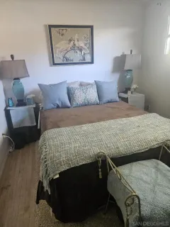 a bedroom with a bed and a lamp on dresser