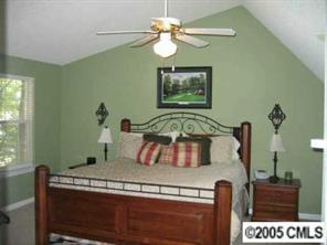 6119 Nevin Road Charlotte, NC 28262 - Photo 7 of 8 a bedroom with a bed and a chandelier