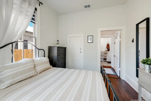 a bedroom with a bed and a flat tv screen on dresser