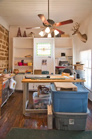 a room with view of kitchen island stainless steel appliances wooden floor and window