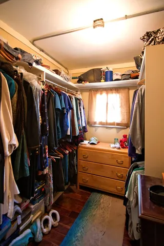 a view of walk in closet with clothes and shoes