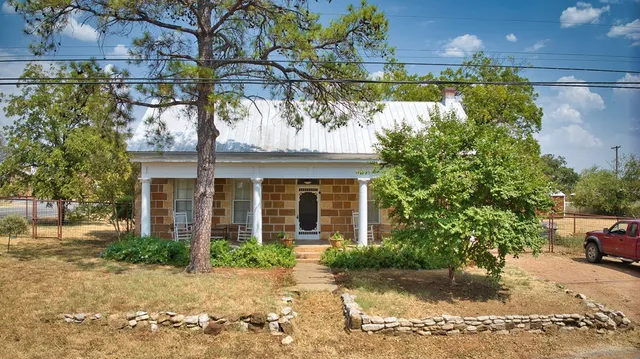a view of a house with a tree in front