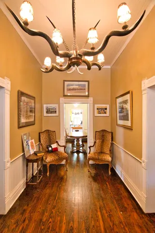 a living room with couches a dining table and chairs with wooden floor