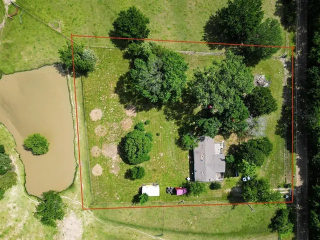 an aerial view of a house with a yard and lake view