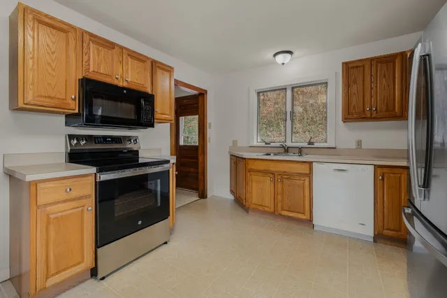 a kitchen with stainless steel appliances a refrigerator sink and cabinets