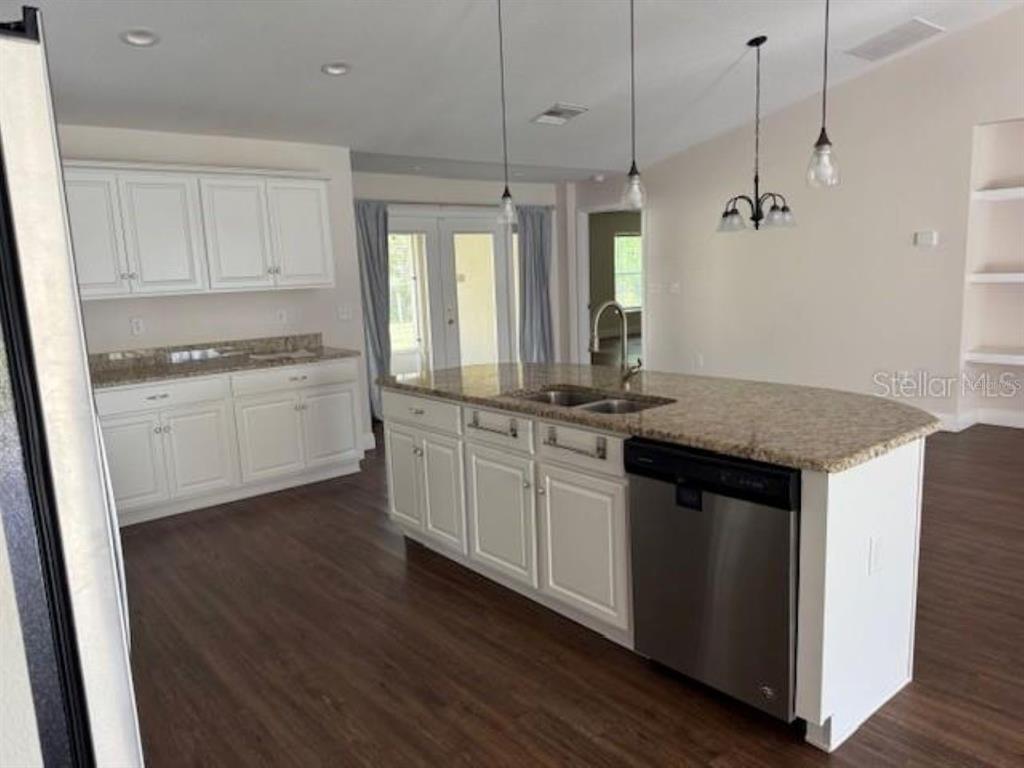 3707 Southeast 24th Street Ocala, FL 34471 - Photo 4 of 14 a kitchen with kitchen island granite countertop a sink cabinets and wooden floor