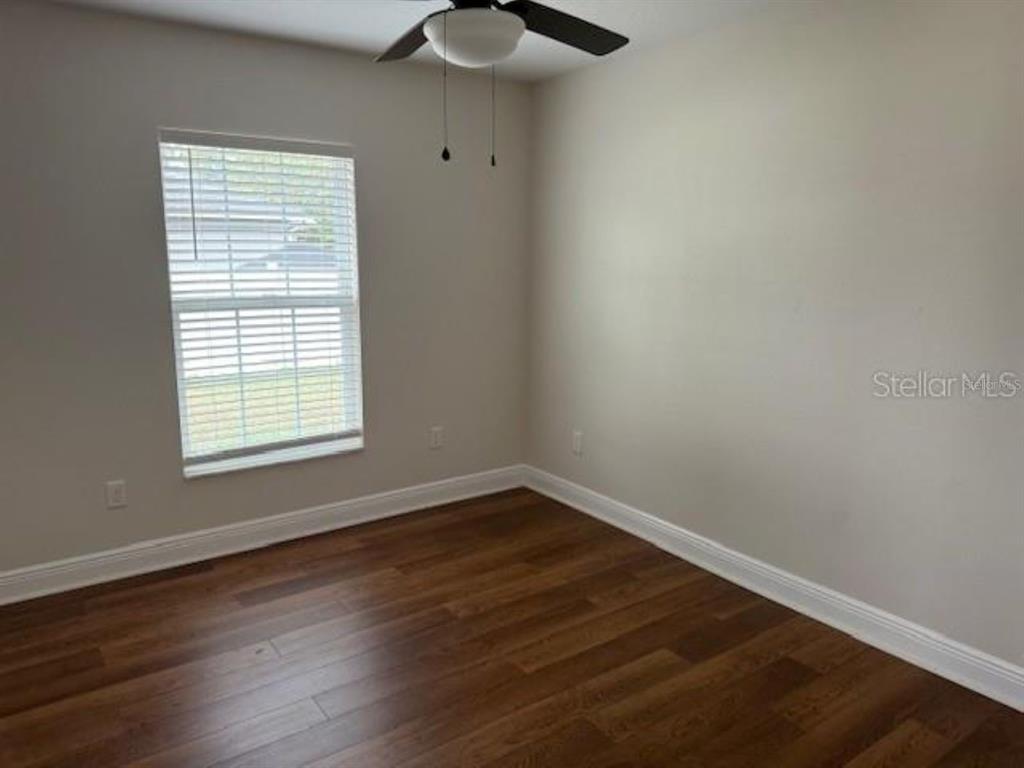 3707 Southeast 24th Street Ocala, FL 34471 - Photo 10 of 14 a view of an empty room with wooden floor and a window