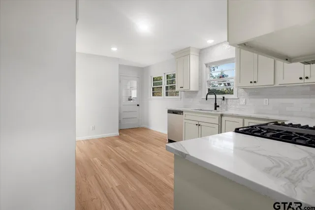 a kitchen with a sink a stove and cabinets