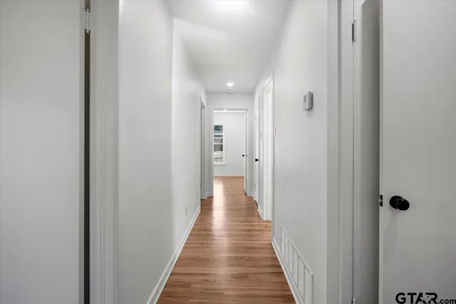 a view of a hallway with wooden floor