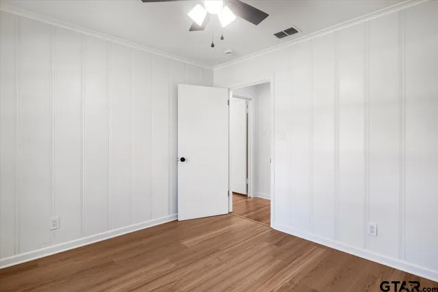 a view of an empty room with wooden floor
