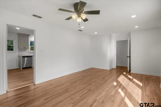 a very nice looking room with wooden floor and a ceiling fan