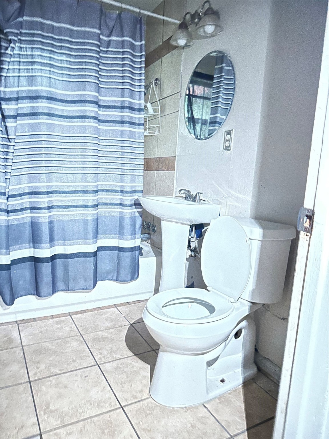 4730 Angleton Street Houston, TX 77033 - Photo 3 of 16 This full bathroom offers both functionality and comfort, featuring a combination tub and shower, a sleek vanity and a large mirror that enhances the space.