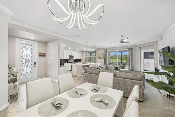 a living room with furniture a dining table and a chandelier