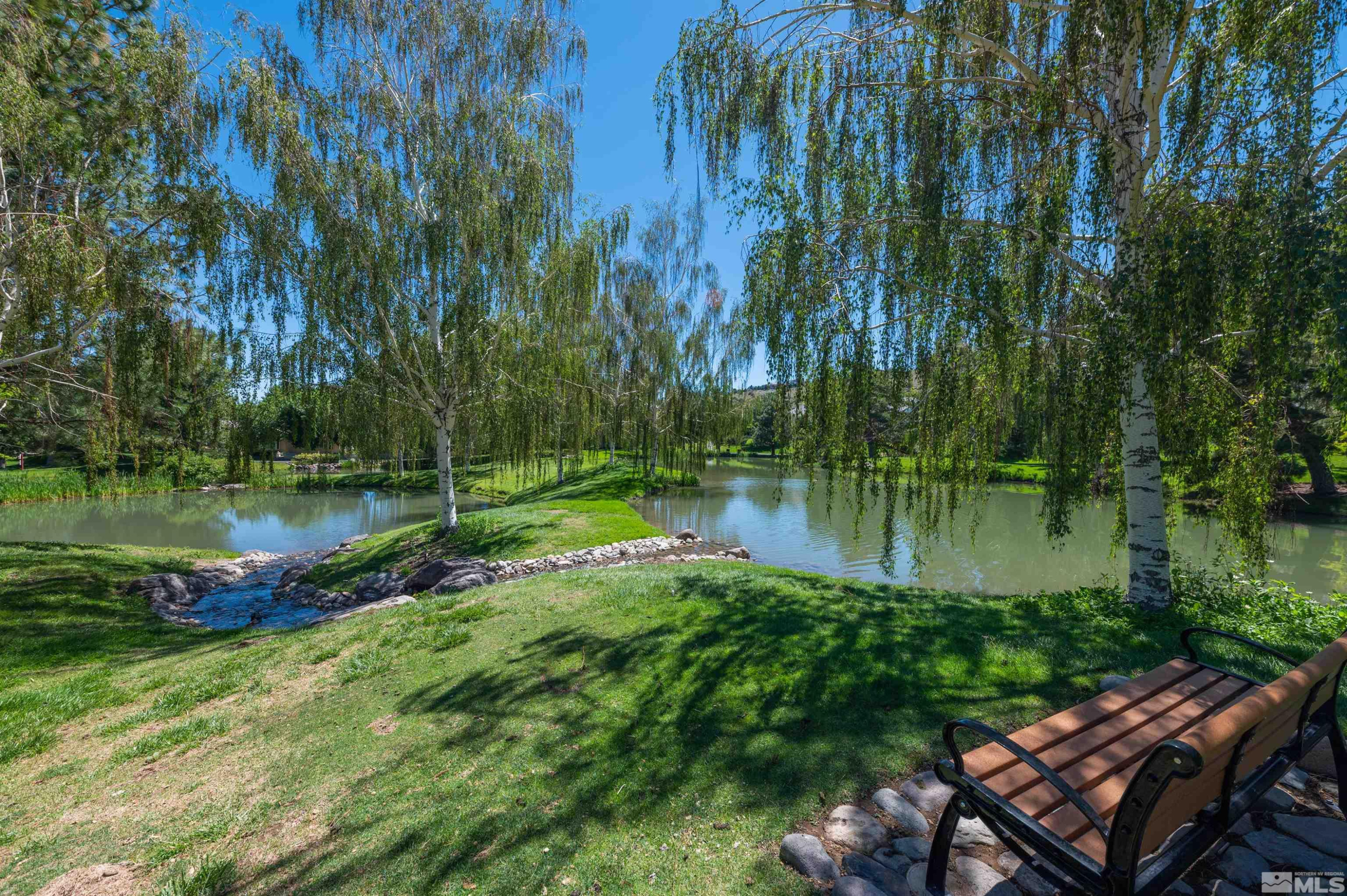 4395 Sharps Road, Unit 714A Reno, NV 89519 - Photo 13 of 15 a view of a lake with a yard and large trees