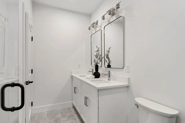 a bathroom with a sink vanity mirror and toilet