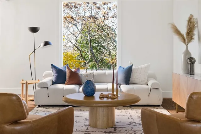 a living room with furniture a lamp and a potted plant