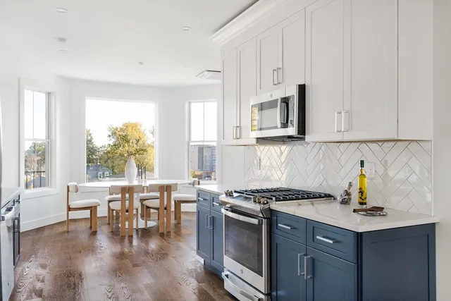 a kitchen with stainless steel appliances granite countertop a stove a sink and a microwave