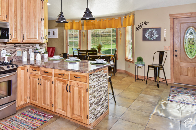 1500 Fish Creek Road Bancroft, ID 83217 - Photo 4 of 45 Kitchen with a kitchen breakfast bar, light brown cabinets, stainless steel appliances, a peninsula, and tasteful backsplash