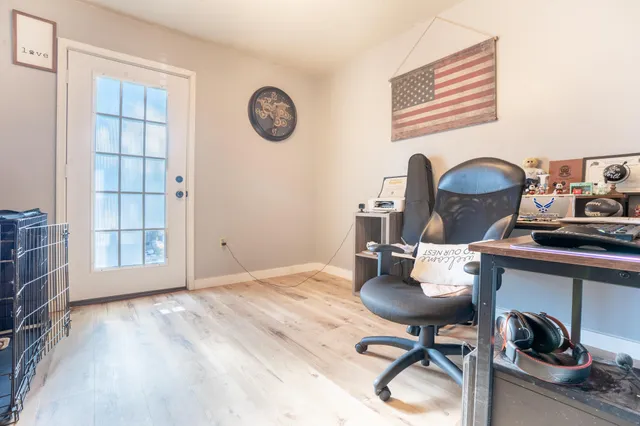 a view of a workspace with furniture and a window