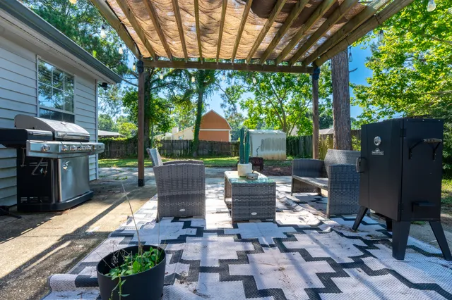 a view of a patio with table and chairs potted plants and large tree
