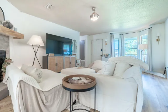 a living room with furniture a fireplace and a flat screen tv