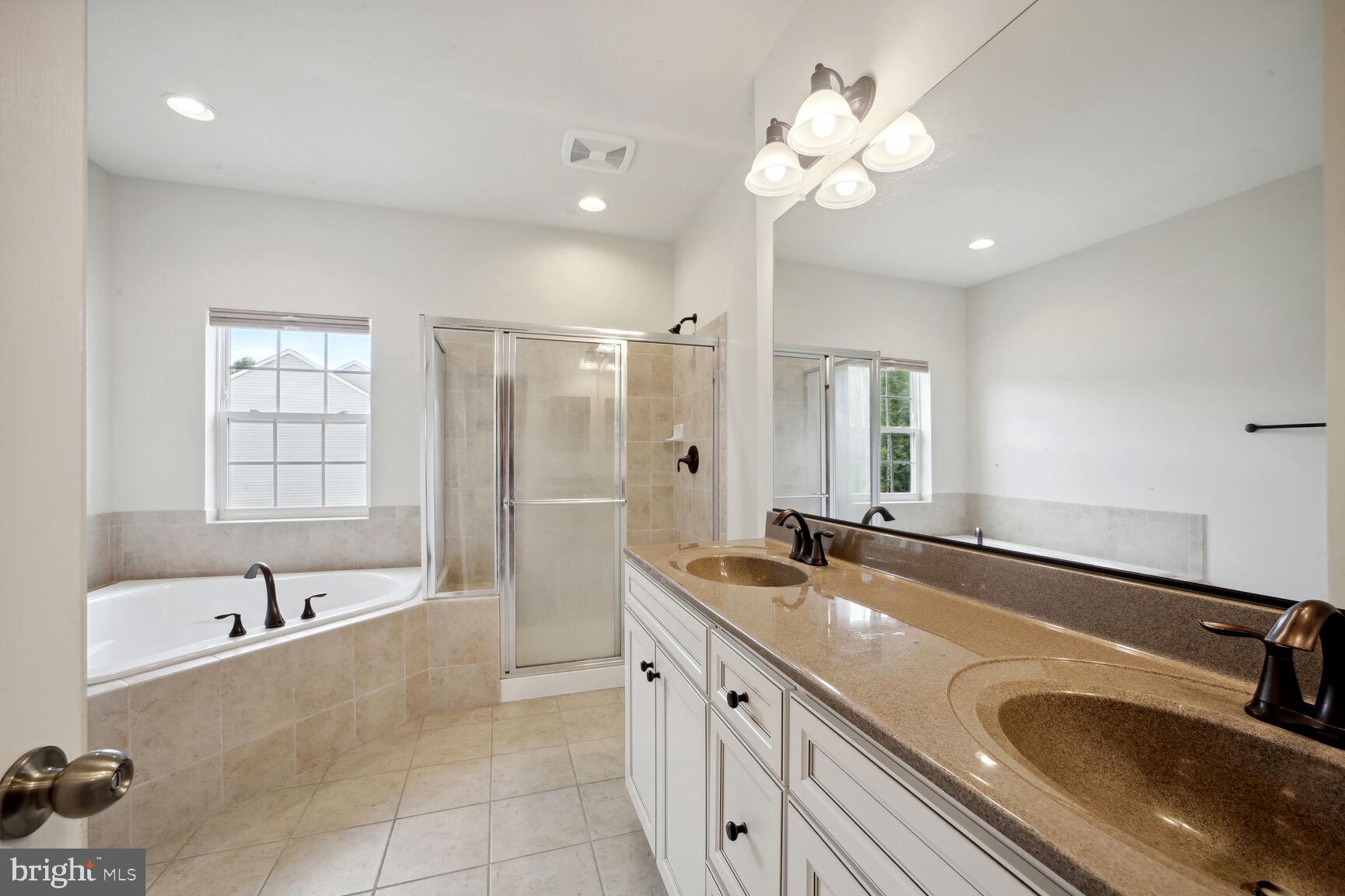 6201 Hunt Weber Drive Clinton, MD 20735 - Photo 17 of 30 a bathroom with a tub sink double vanity granite tub shower and mirror