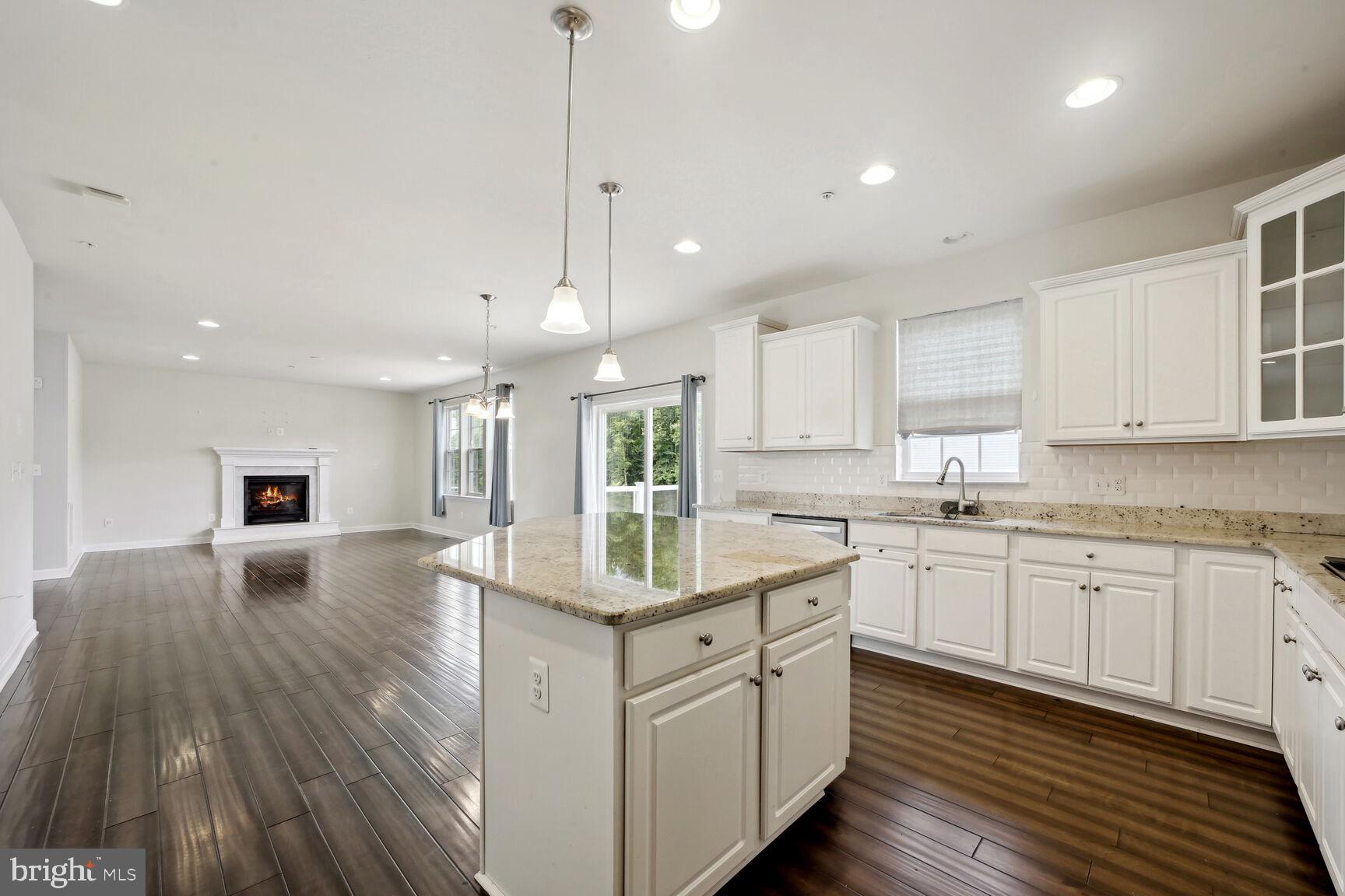 6201 Hunt Weber Drive Clinton, MD 20735 - Photo 8 of 30 a kitchen with kitchen island granite countertop a sink cabinets and wooden floor