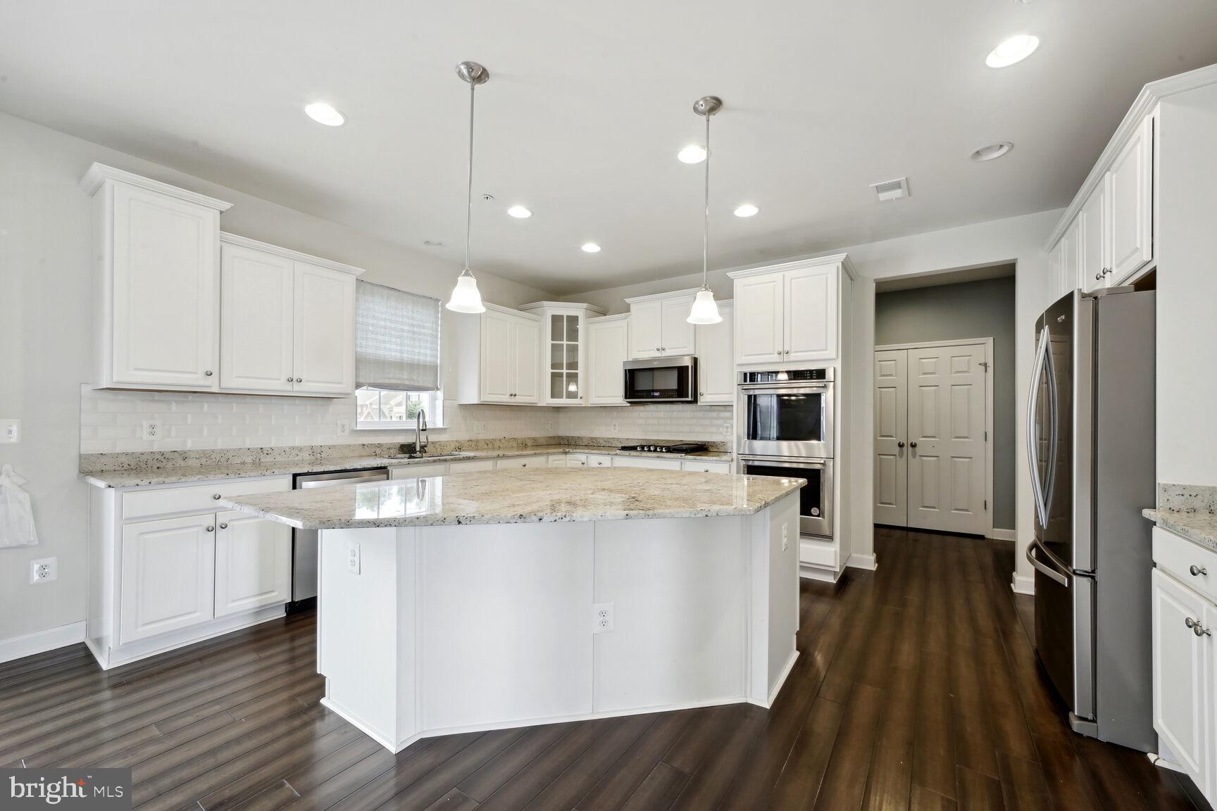 6201 Hunt Weber Drive Clinton, MD 20735 - Photo 10 of 30 a large kitchen with stainless steel appliances granite countertop a stove a sink and a refrigerator