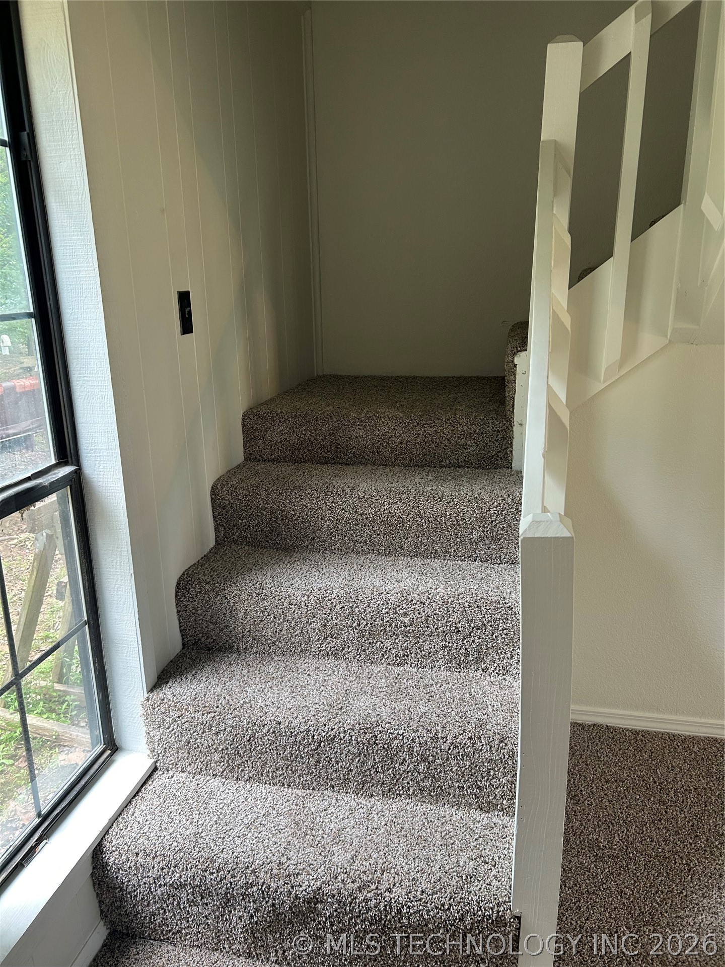 110955 East 1110 Road Sallisaw, OK 74955 - Photo 14 of 22 Carpeted staircase with white balusters and a large window featuring grid panes