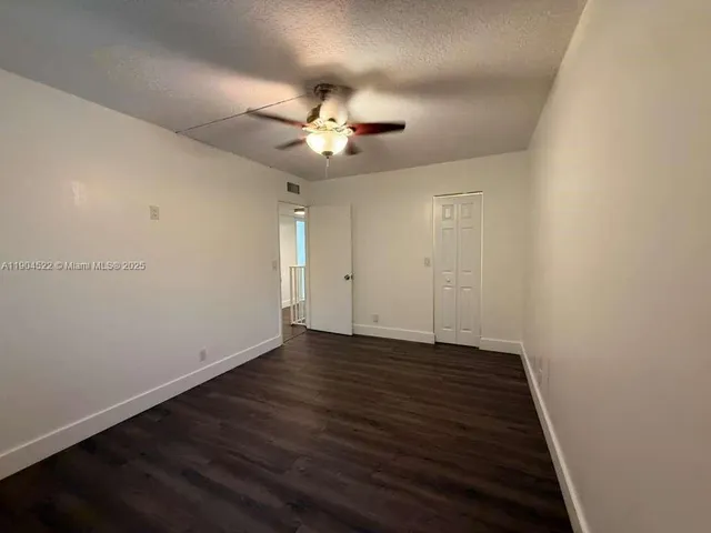an empty room with wooden floor and entrance