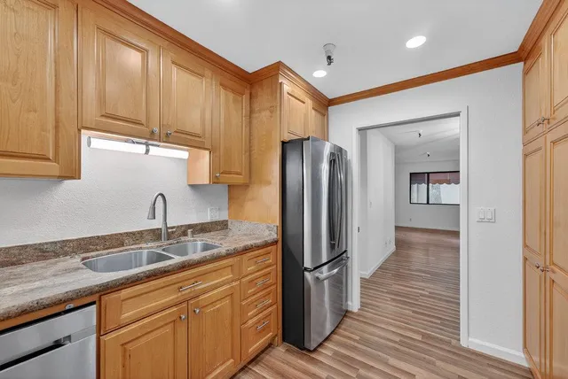 a kitchen with stainless steel appliances granite countertop a refrigerator and a sink