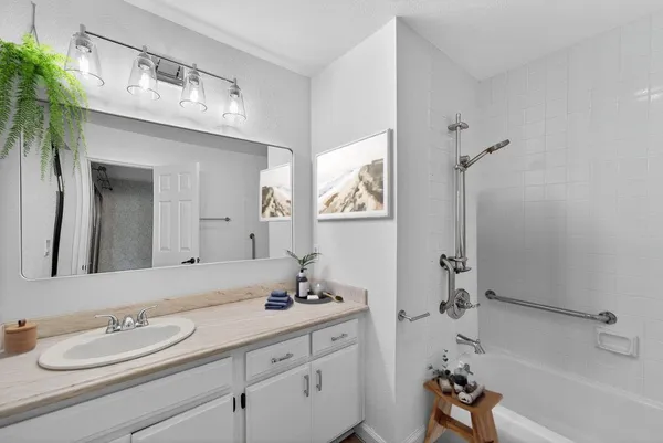 a bathroom with a tub sink and mirror
