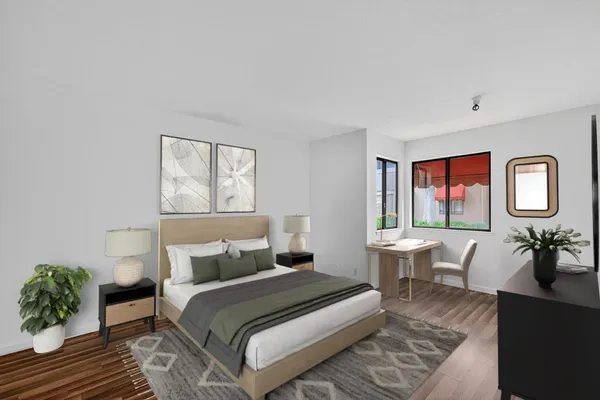 a bedroom with a large bed and windows