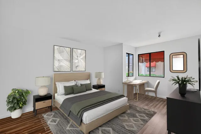 a bedroom with a large bed and windows