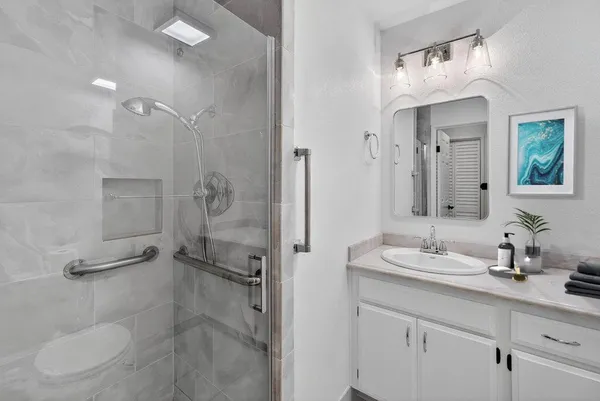 a bathroom with a double vanity sink mirror and shower