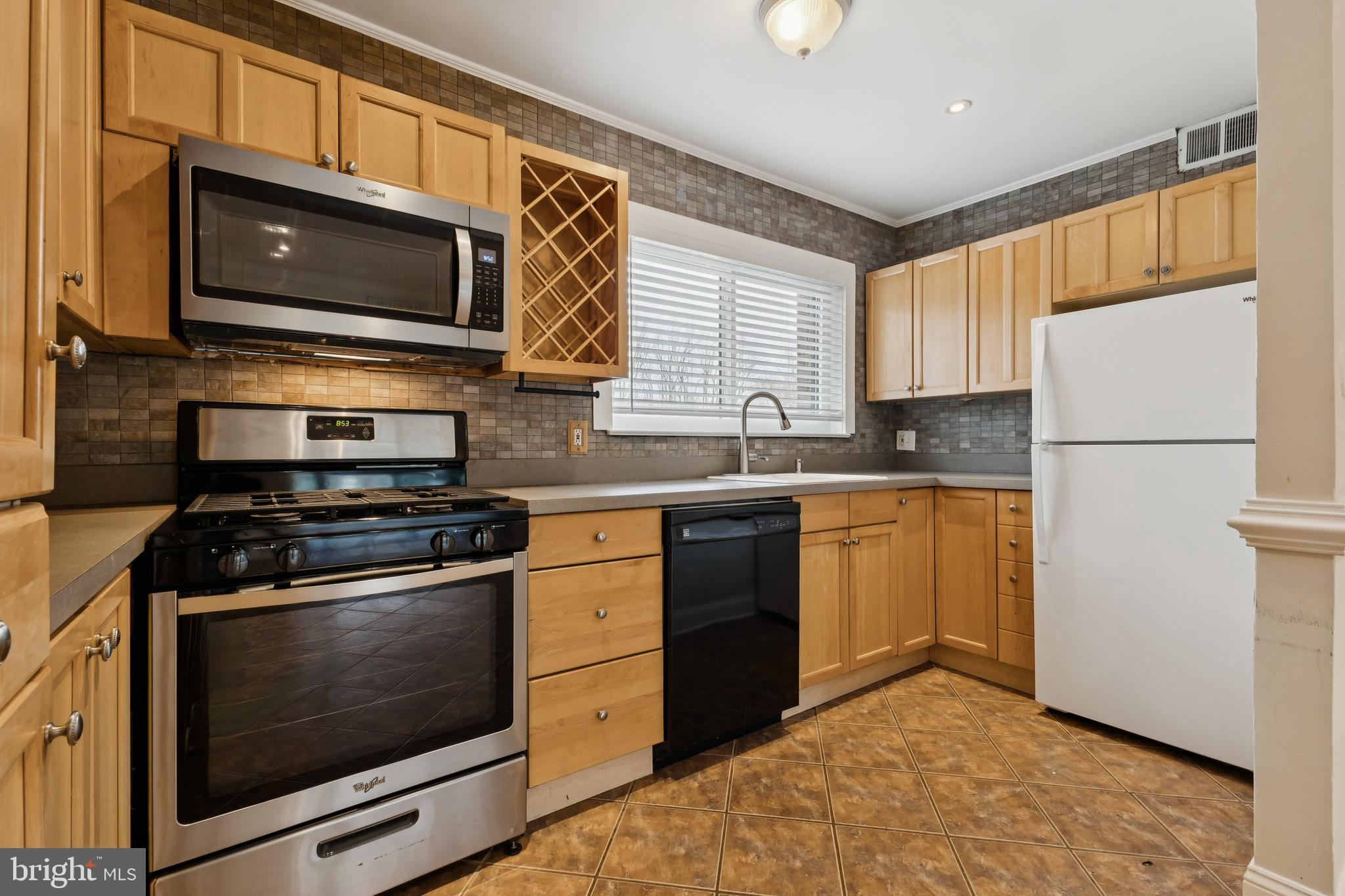 a kitchen with stainless steel appliances granite countertop a stove microwave sink and refrigerator