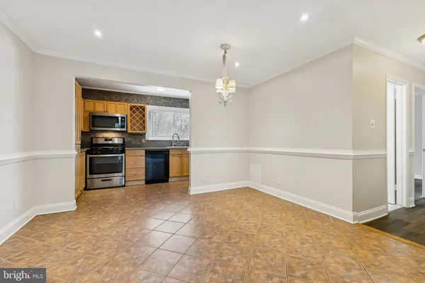 a view of a kitchen with a sink and an empty room