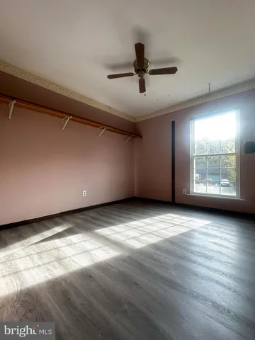 a view of a livingroom with a ceiling fan and window