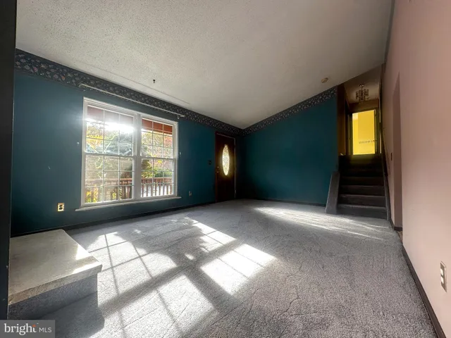 a view of an empty room with a fireplace and windows