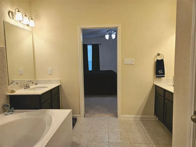 a en suite bathroom with a tub sink and mirror