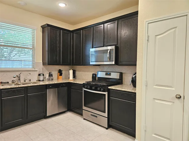 a kitchen with stainless steel appliances granite countertop a stove and a refrigerator