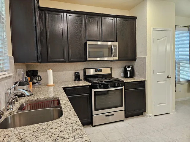 a kitchen with a sink stove and microwave