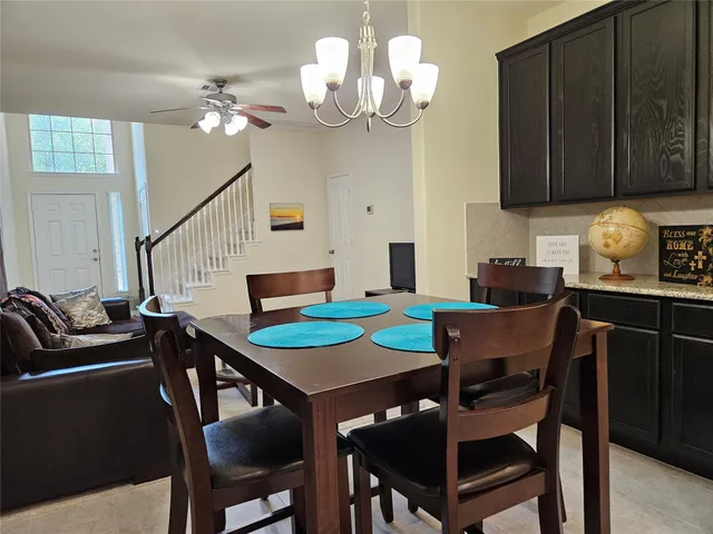 a dining room with wooden floor a chandelier a wooden table and chairs