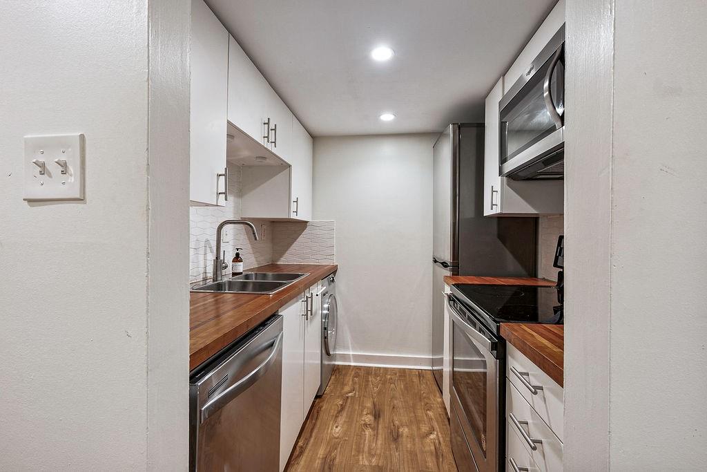 1133 Clairemont Avenue, Unit D Decatur, GA 30030 - Photo 7 of 20 a kitchen with stainless steel appliances granite countertop a stove and a refrigerator