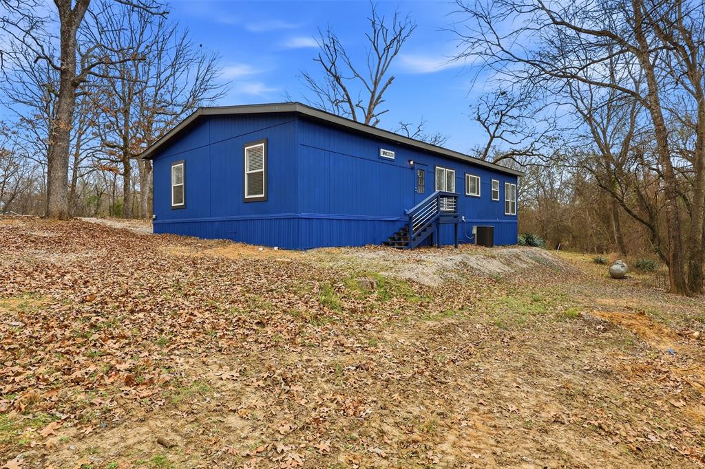 2114 Hickory Street Mabank, TX 75156 - Photo 23 of 31 Back of home with stairs to back door and mature trees
