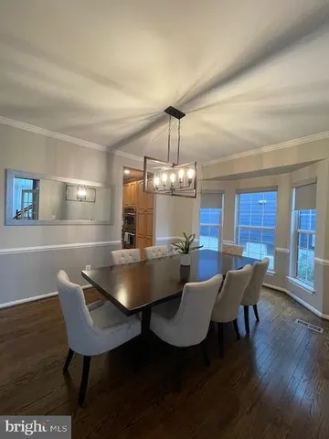 a view of a dining room with furniture wooden floor and chandelier